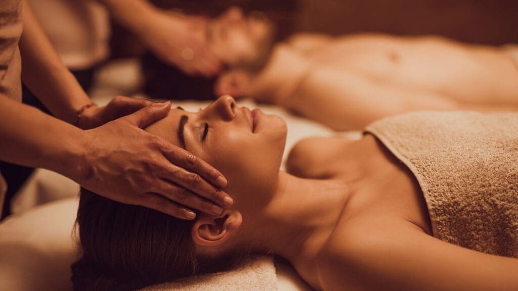 A couple enjoying a romantic massage experience at a serene spa on a cruise.
