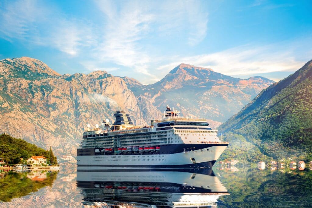 Cruise ship sailing through dramatic mountain scenery, showcasing an inspiring and relaxing travel experience for teachers.