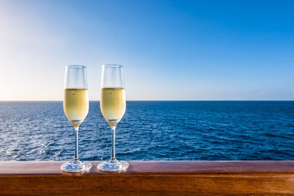Celebratory champagne on a cruise ship overlooking the ocean, marking a well-deserved break for teachers.