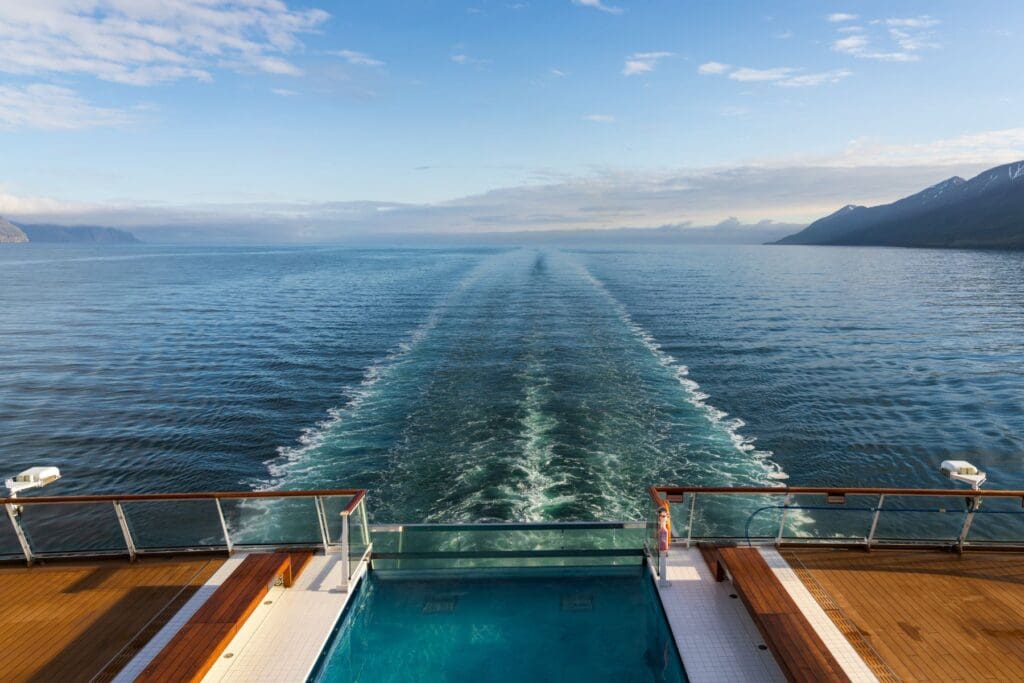 Cruise ship wake stretching into the ocean, symbolizing a peaceful cruise vacation for teachers.