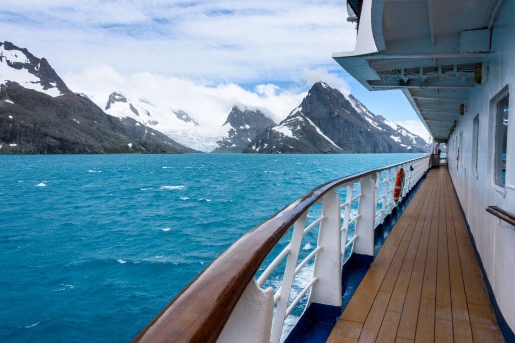 Cruise ship sailing through scenic waters, showing the immersive travel experiences available with teacher cruise discounts.
