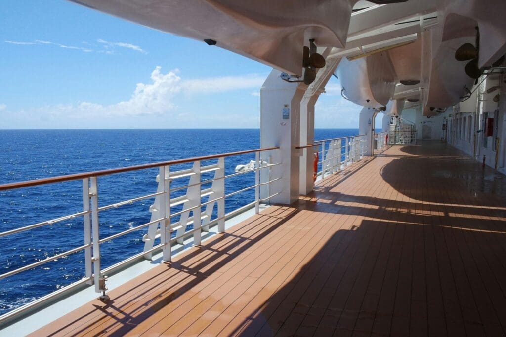Empty lounge chairs on a cruise ship deck, illustrating the restful sea days possible with teacher cruise discounts.